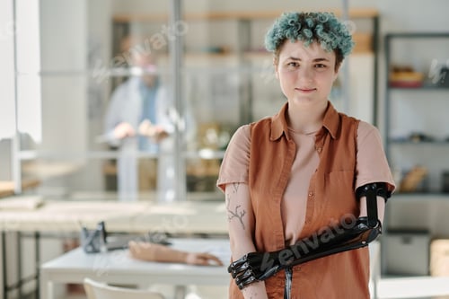 Preview: Young woman with bionic prosthetic arm smiling at camera