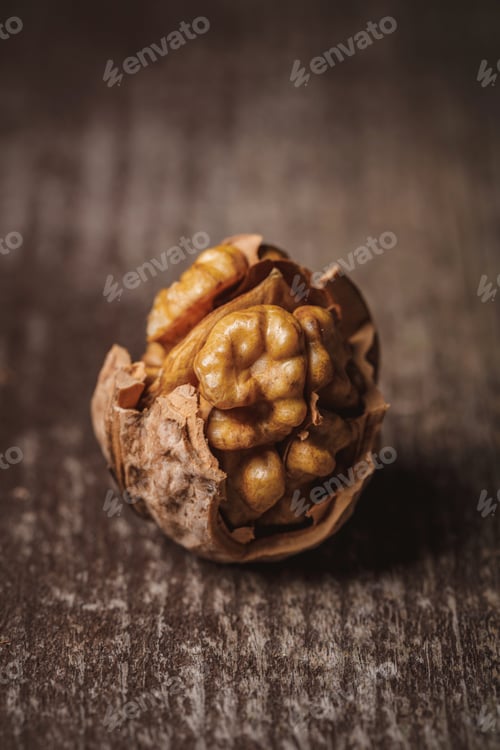 Preview: close up view of shelled walnut on wooden tabletop