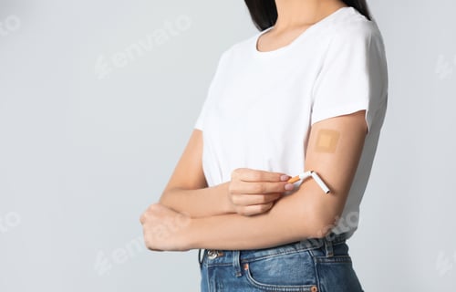 Preview: Young woman with nicotine patch and cigarette on light grey background, closeup