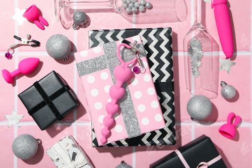 Preview: Sex toys with Christmas gifts on the background.