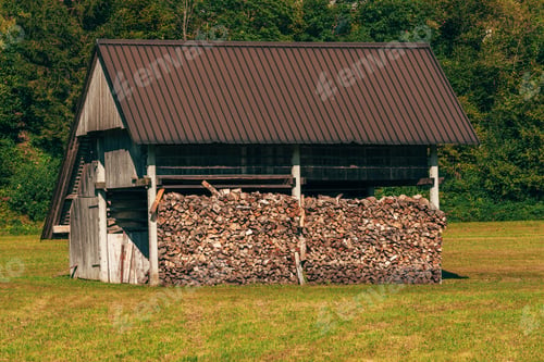 Preview: Stacked chopped firewood in farm shed for winter season