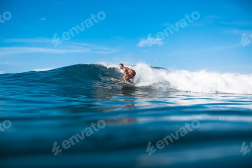 Preview: young sporty man having fun on surfboard on sunny day