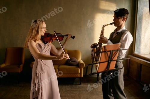Preview: Young female violinist and male saxophonist training at home
