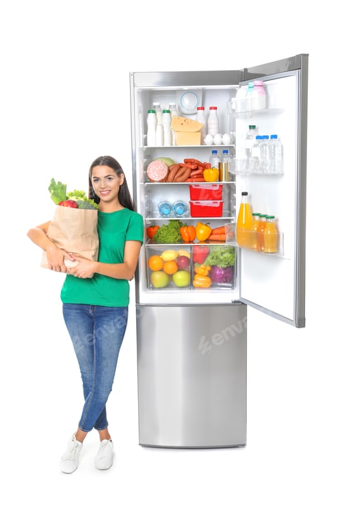 Preview: Young woman with bag of groceries near open refrigerator on white background