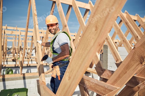 Preview: Construction worker wearing a helmet and holding a drill