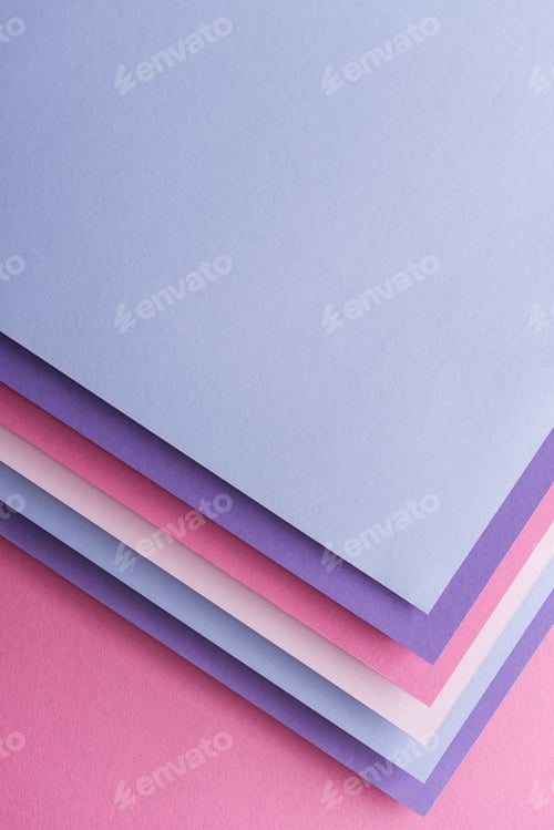 Preview: top view of blue, white, pink and purple sheets of paper on pink background with copy space