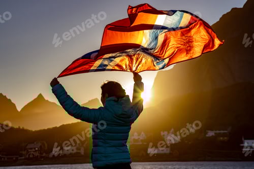 Preview: Woman waving the flag of Norway at sunset