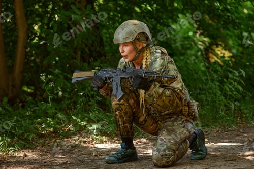 Preview: Caucasian Military lady woman in tactical gear posing for photo at summer season. Wearing green camo