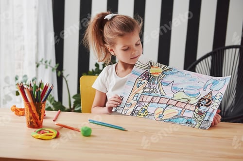 Preview: Cute little girl in art school shows her first picture drawn by pencils and markers