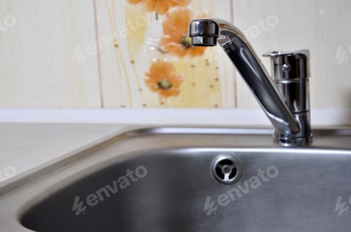 Preview: Empty clean silvery kitchen sink and water faucet close up indoors