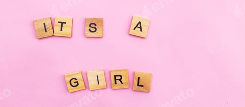 Preview: Word Its a girl by wooden cubes on pink background. Symbol of childbirth, parenthood, birth concept