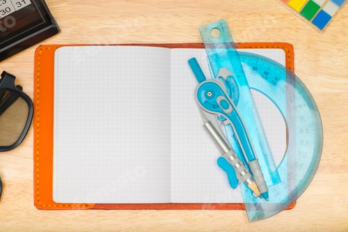 Preview: Top view of notebook with Compasses circle and eyeglasses,calendar on wooden table