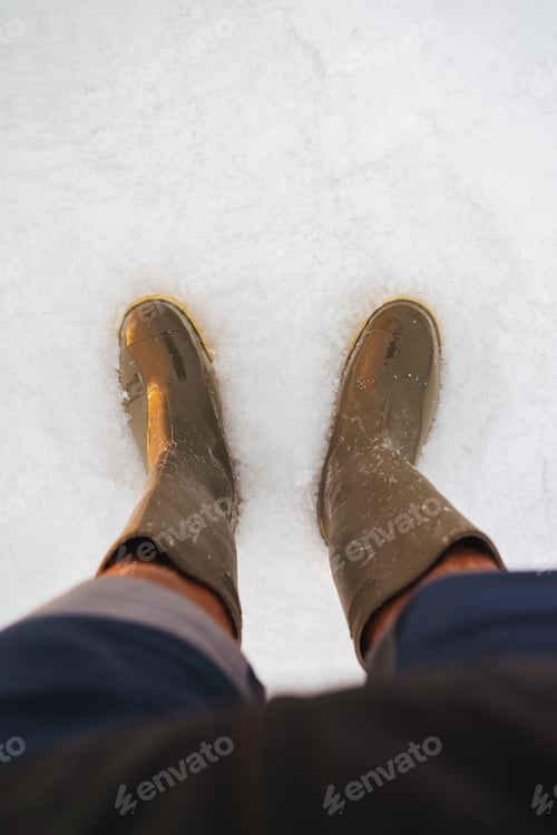 Preview: Point of view high angle shot of a person with boots at Uyuni Salt flats with water in Bolivia
