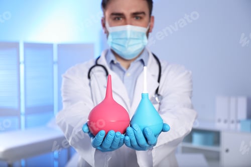 Preview: Doctor holding rubber enemas in examination room, focus on hands