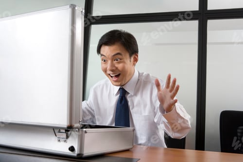 Preview: Young businessman opening a case with big surprise