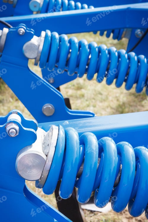 Preview: Big and hard blue steel spring as part and detail of industrial or agricultural machine