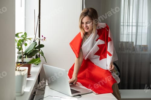 Preview: female student sitting with canadian flag and using laptop