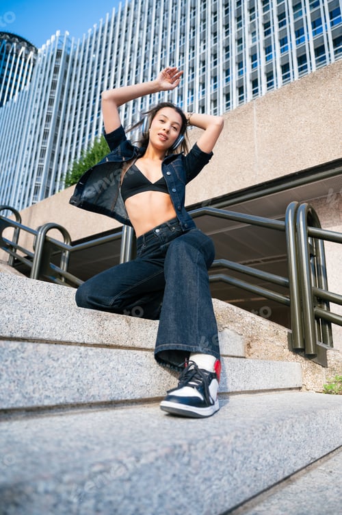 Preview: Young woman dancing urban street wearing headphones
