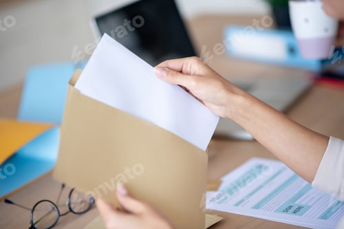 Preview: Close up of woman taking letter out of envelope