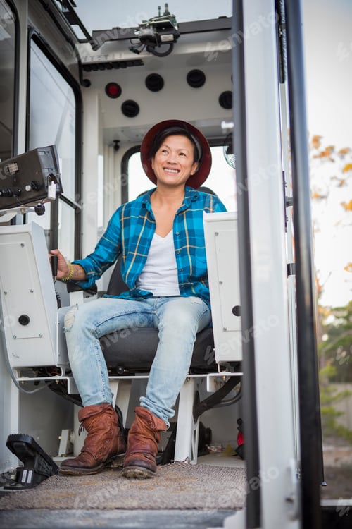 Preview: Mature female crane operator operating crane on building site