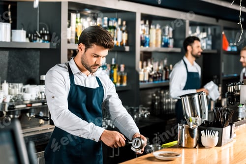 Preview: handsome barista preparing coffee at wooden counter