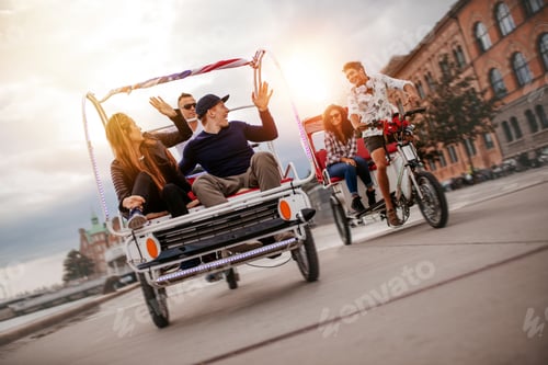 Preview: Group of friends having fun with two tricycles on road
