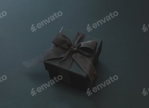 Preview: Black Friday Sale. Gift box with curly ribbon isolated on black, close up