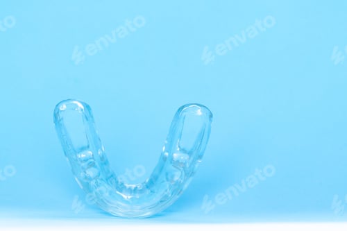 Preview: Silicone dental mouthguard, orthodontic trainer to correct bite on blue background,