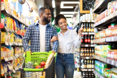 Preview: Cheerful Black Spouses Choosing Food In Grocery Store