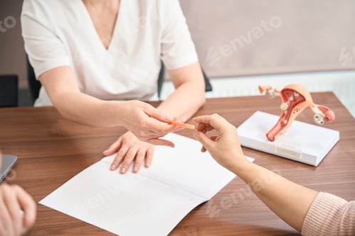 Preview: Close-up woman taking a pen to signing the contract with gynecologist