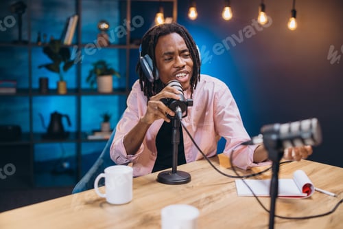 Vista previa: African American male content creator recording podcast audio, working with professional microphone