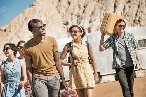 Preview: A group of people walking in a line in open desert country, carrying their cases, on a road trip.