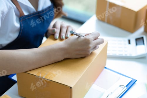 Preview: Small business entrepreneur SME or freelance Asian woman working with parcel box at home.