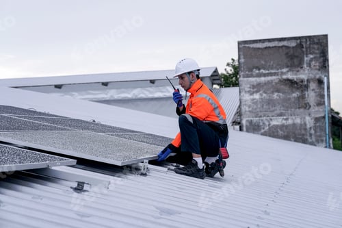 Preview: Engineer installing solar panels on wet metal rooftop during cloudy weather
