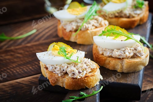 Preview: Toasted bread with a salted codfish mousse on wooden cutting board
