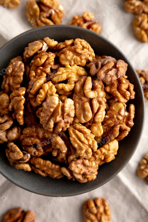 Preview: Raw Walnut Halfs in a Bowl, top view. Flat lay, overhead. Close-up.