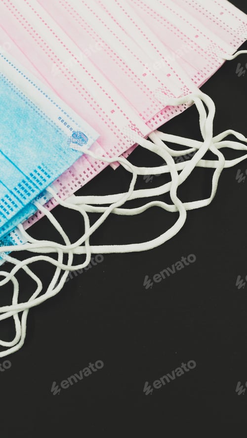 Preview: Vertical shot of surgical masks on a black surface