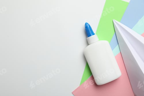 Preview: Glue and color paper on white background, flat lay. Space for text
