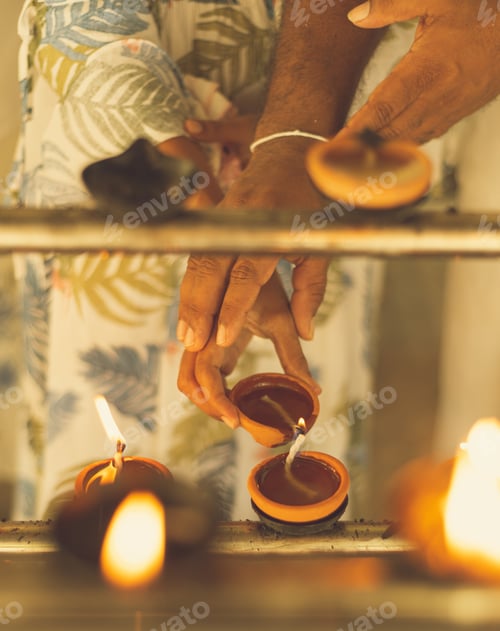 Preview: Couple lighting the clay oil lamps together at the temple. putting hands on top of each other