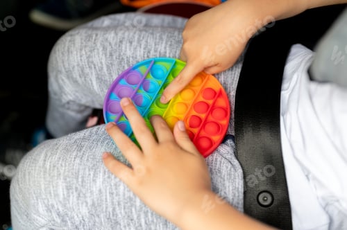 Preview: kids anti stress sensory pop it fidget push toys in kid's hands. child playing with a toy in a car