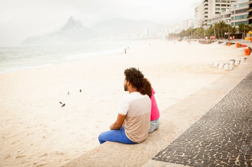 Preview: Couple sitting looking out from Ipanema beach, Rio De Janeiro, Brazil