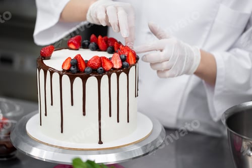 Preview: Pastry chef decorates the cake with chocolate streaks of strawberries and blueberries