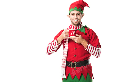 Preview: smiling man in christmas elf costume holding cup of tea and looking at camera isolated on white