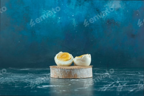 Preview: Boiled and half cut egg on a wooden board
