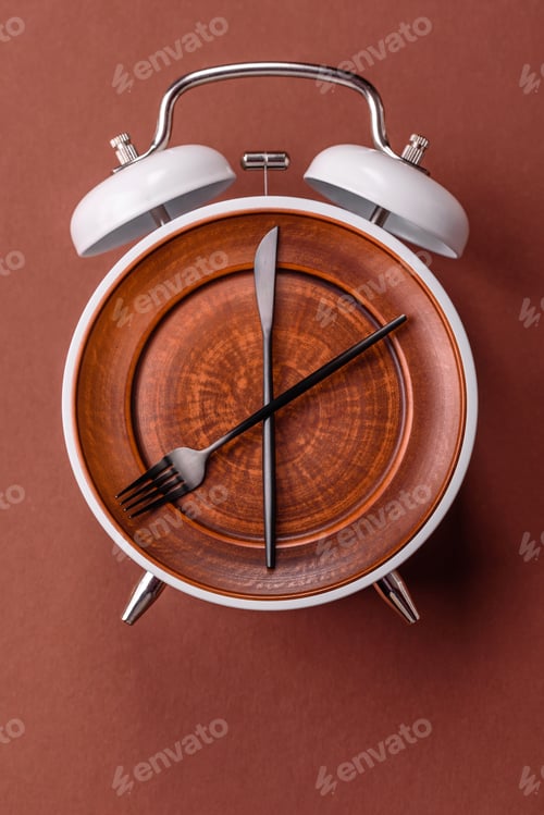 Preview: Empty plate with devices in the form of clock hands as a conceptual background for lunch time