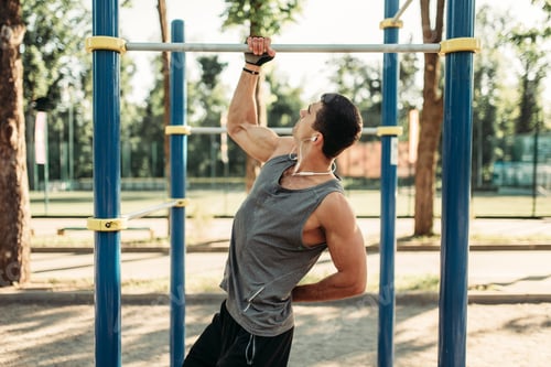 Preview: Athletic man pulled up on one hand outdoor