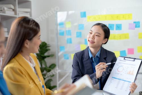 Preview: Asian businesswomen collaborate and discuss business plan during team meeting in modern office.