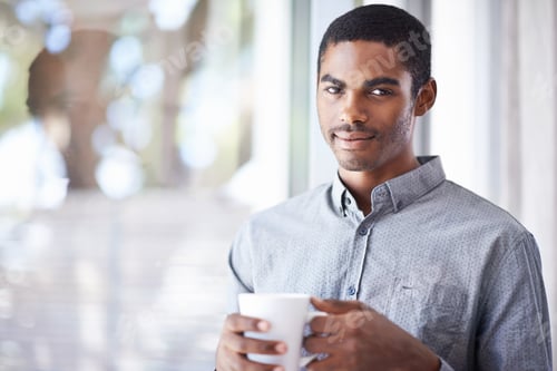 Young Man Enjoying Coffee Indoors by Window