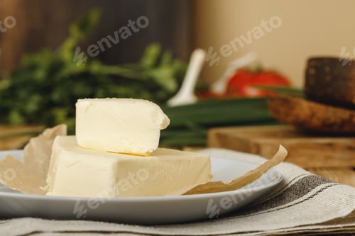 Preview: Slices of butter in a plate on wooden table