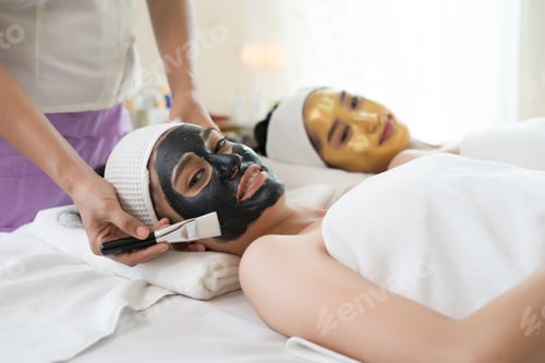 Preview: Beautiful woman getting facial mask at beauty salon.